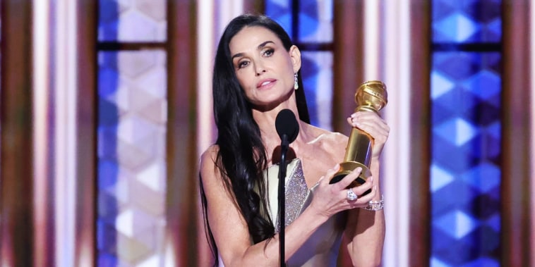 Demi Moore holds an award on stage