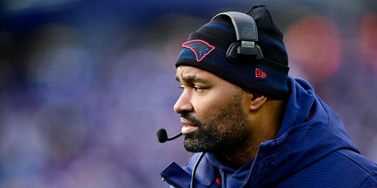 Jerod Mayo looks across the football field from the sidelines