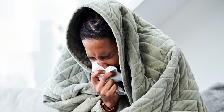 Shot of a young man with the flu sitting on the couch at home.