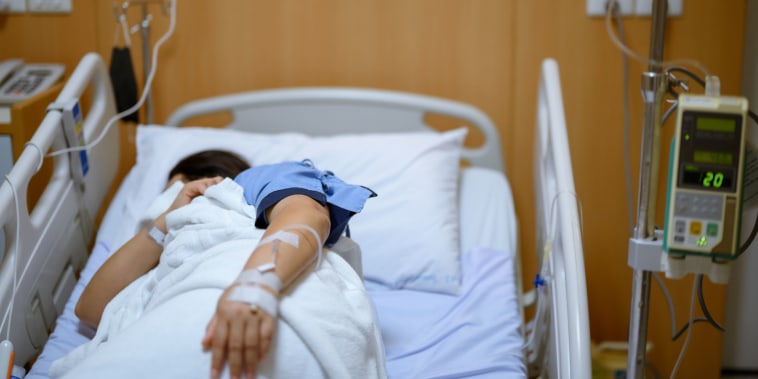 A patient lies on a bed with a mask in the recovery room in the hospital department.