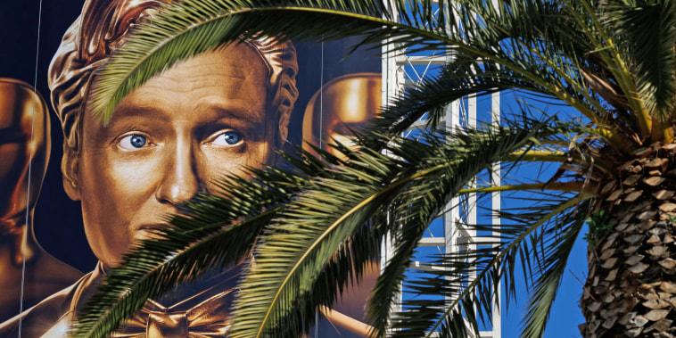 A large billboard features Oscar host Conan O'Brien