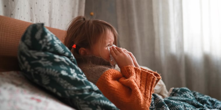 Seasonal Sniffles: Child in Sweater, Wrapped in Blankets, Battling Seasonal Cold.