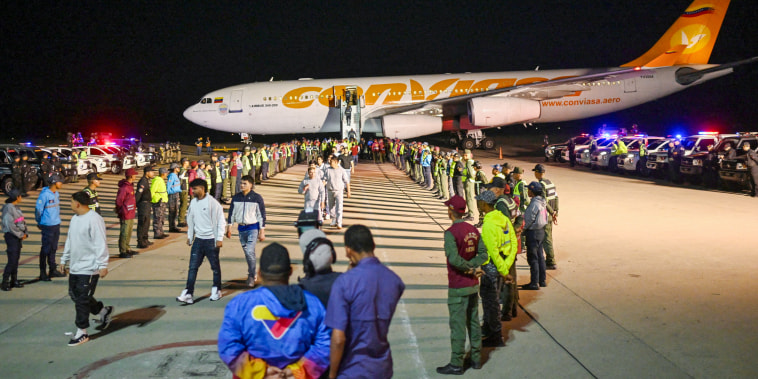 Venezuelan migrants disembark planes.