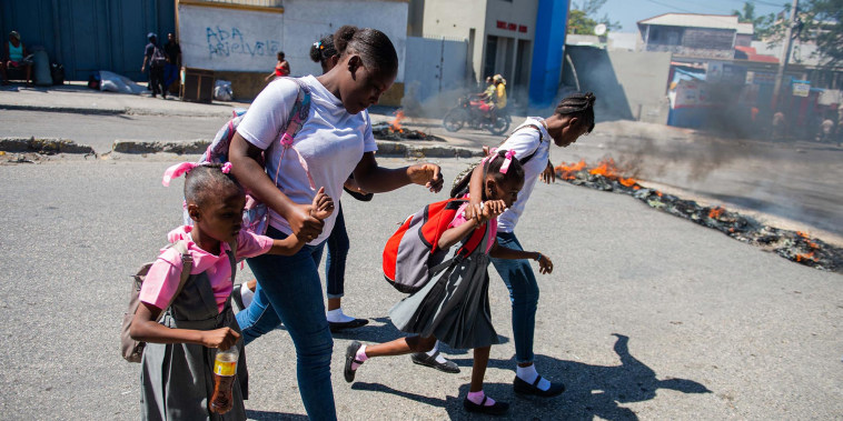 People flee gang violence during an anti-government demonstration in of Port-au-Prince, Haiti, on Feb. 20, 2025.