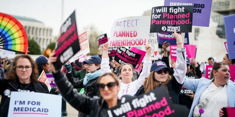 Protestors hold signs in support of Planned Parenthood