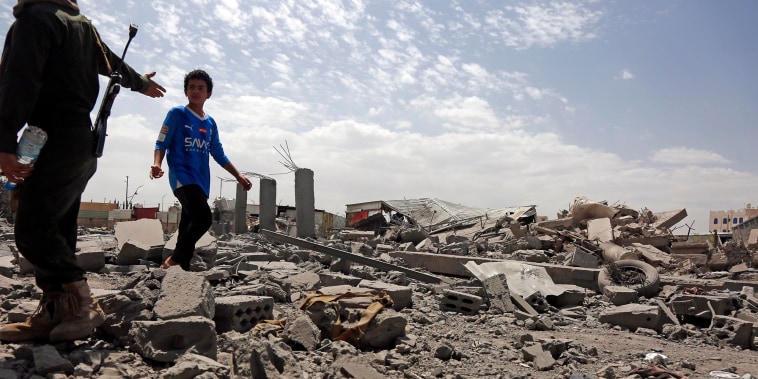 A security guard asks a child to stop walking over the rubble of a building destroyed by U.S. strikes on April 27, 2025 in Sana'a, Yemen. 