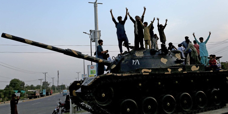 Pakistanis flash victory signs as they celebrate the ceasefire between Pakistan and India in Multan on May 10, 2025. 