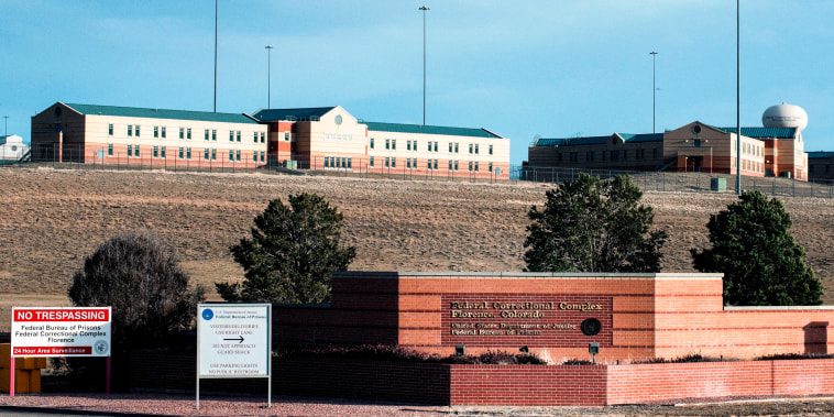 The exterior of a prison campus, a building is seen in the distance