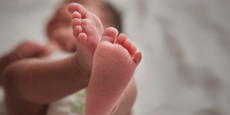 Close up of mixed race newborn baby girl's feet