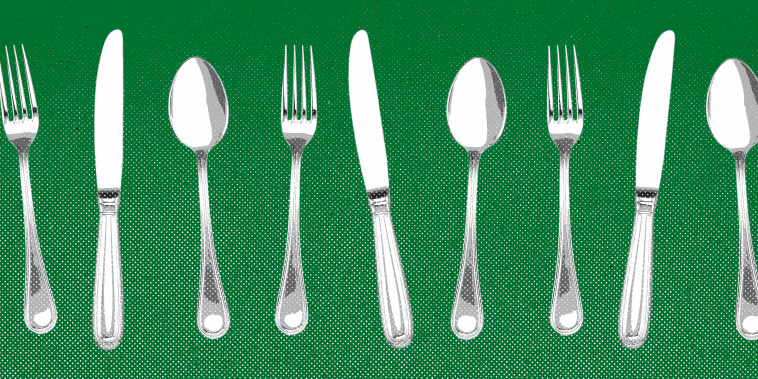 Forks, knives, and spoons lined up against a green background.