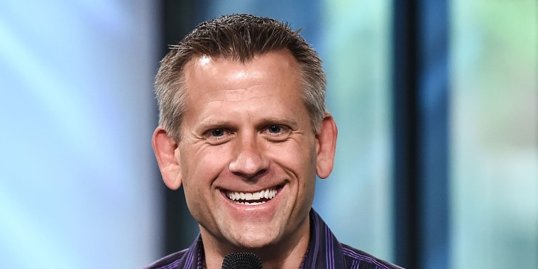 John Brenkus smiles while he speaks.