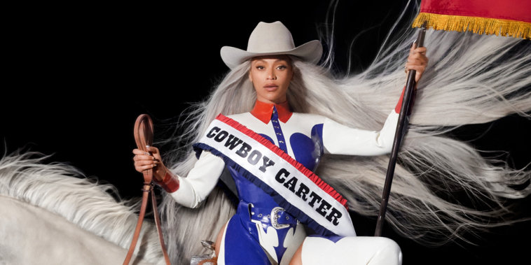 Beyonce sitting on a white horse wearing a sash that says "Cowboy Carter" and waving the American flag