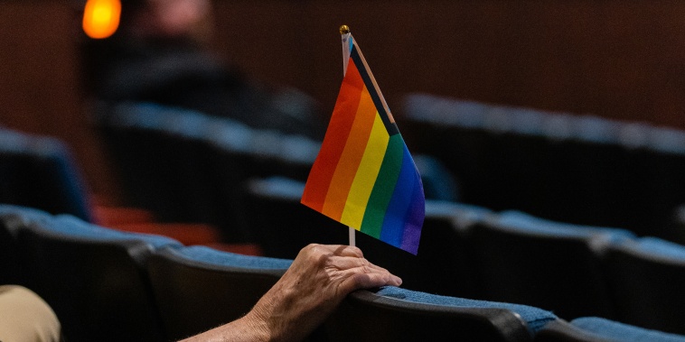 A person holds an inclusive pride flag during a Fairfax County School Board meeting after a rally in support of inclusive Family Life Education at Luther Jackson Middle School in Falls Church, Va. on July 14, 2022. 