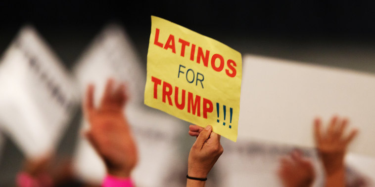 A supporter holds a sign that reads " Latinos for Trump"