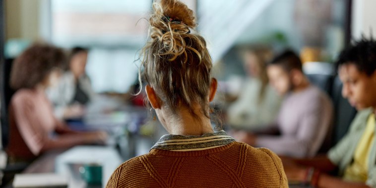Back view of creative woman on a meeting in the office.