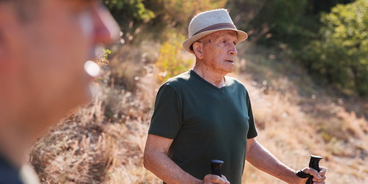 Senior man walking with hiking poles