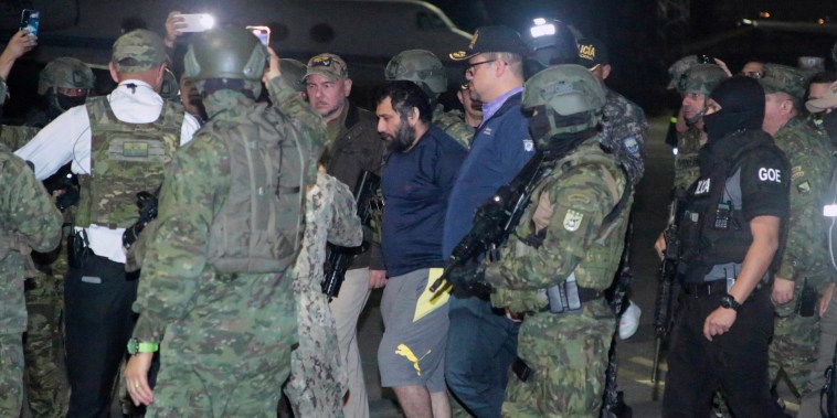 Escoltado por soldados y policías, Adolfo "Fito" Macías (centro) llega a Guayaquil, Ecuador, tras ser recapturado, el 25 de junio de 2025. 