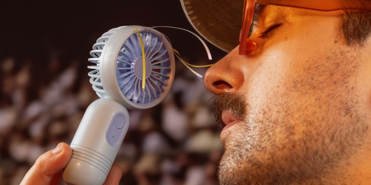 a man holding a portable fan