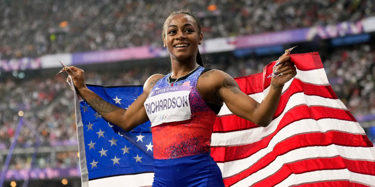 Sha'carri Richardson holds the U.S. flag.