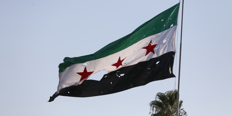 A tattered Syrian flags blows in the wind