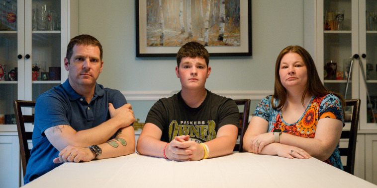 From left, Nick, Jonathan, and Misty Benz-Bushling sit at their kitchen table to pose for a photo