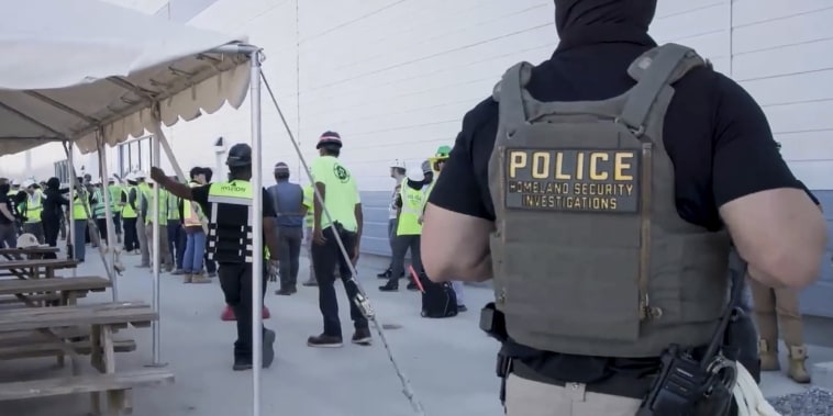 manufacturing plant employees being escorted outside the Hyundai Motor Group’s electric vehicle plant by officers