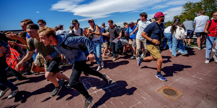 People run after a shot was fired at U.S. right-wing activist and commentator Charlie Kirk at a Utah Valley University speaking event in Orem