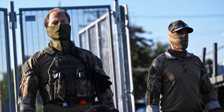 Federal Agents stand outside the Immigration and Customs Enforcement facility.