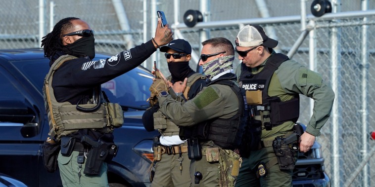 ICE agents use their phones near protestors at a demonstration in Newark, N.J. on May 7, 2025.