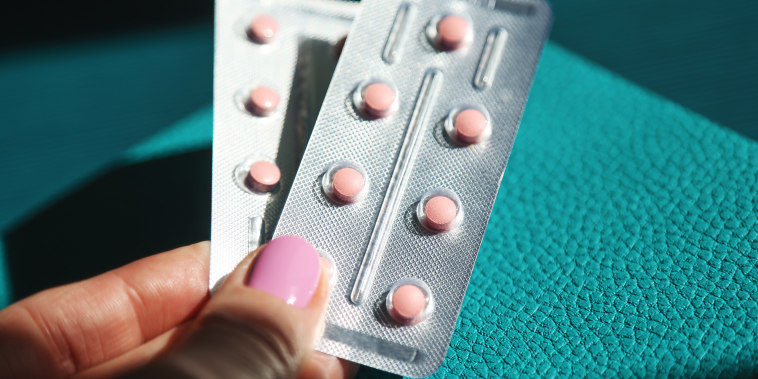 Woman's hands holding HRT pills