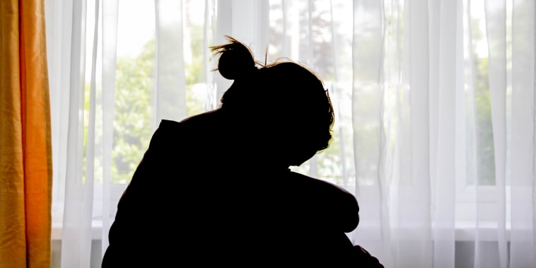 Silhouette of a woman in front of the window.