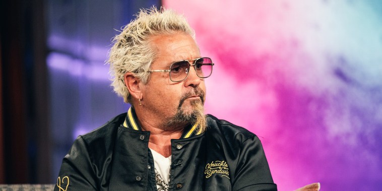 Guy Fieri seated on a couch