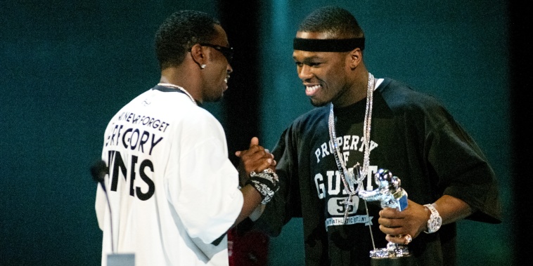 Diddy, left, and 50 Cent shake hands on stage
