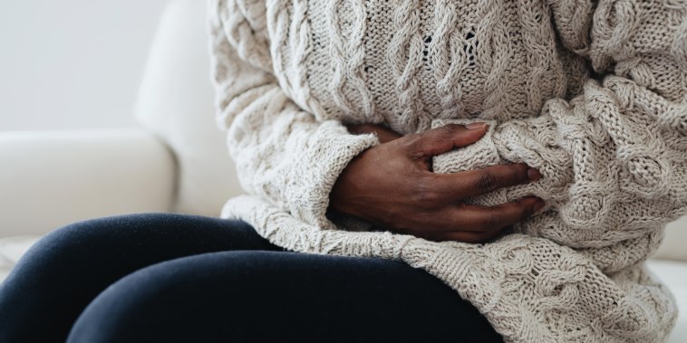 Woman Holds Abdomen in Pain