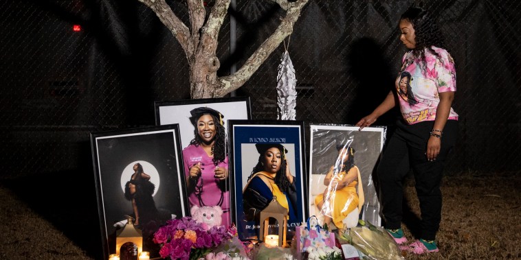Selina Green, sister of Dr. Janell Green Smith, stands next to a collection of photos, flowers and candles arranged for her former sister, on Jan. 7, 2026, on Charleston. Smith was a former midwife and maternal rights advocate that died after giving birth to her own child.