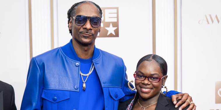 Snoop Dogg, left, places his arm around Cori Broadus' shoulder, right