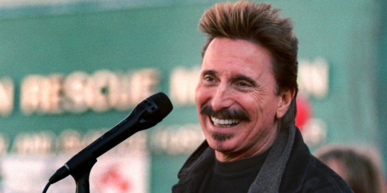 Chuck Negron sings into a microphone