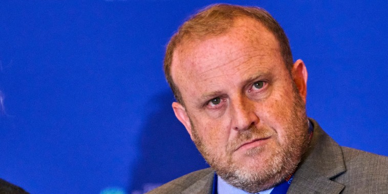 Jeremy Carl staring away while wearing a suit and a tie.
