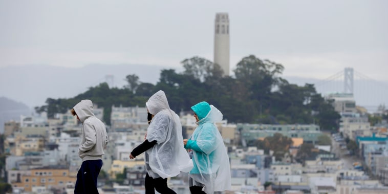 People wear rain ponchos;