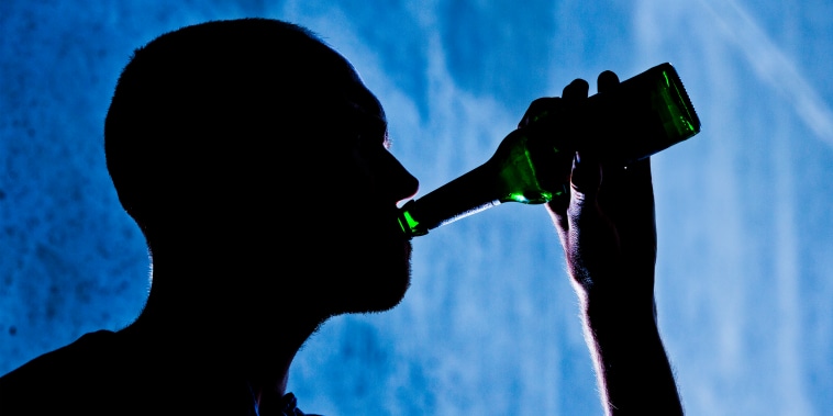 A man is seen drinking from a beer bottle