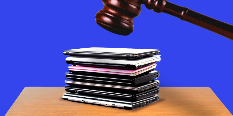 Gavel hovering above stack of laptops 