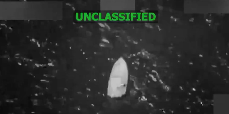 A grainy black-and-white still image taken from video shows a boat floating in the water.