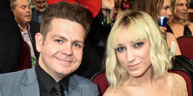 Jack Osbourne and Aree Osbourne smile for a portrait together while seated