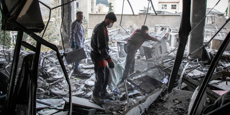 People work to recover items from a building hit by a strike