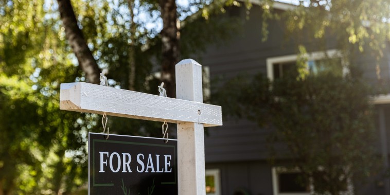 Image: Image of a real estate for sale sign posted in front of a residential home