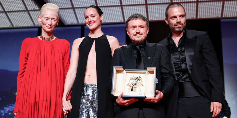 From left, Tilda Swinton, Renate Reinsve, Cristian Mungiu, and Sebastian Stan pose together for a photo as Cristian holds the Palme d'Or prize trophy