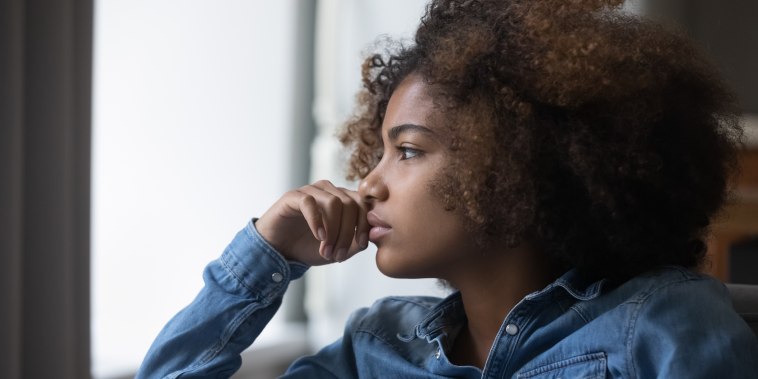 Closeup face African sad thoughtful teenager girl looking into distance