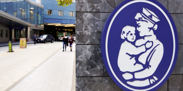 The logo of a nurse holding a child hangs on a wall outside the Boston Children's Hospital, on Aug. 18, 2022.
