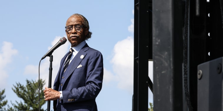 Al Sharpton standing at a microphone outdoors.