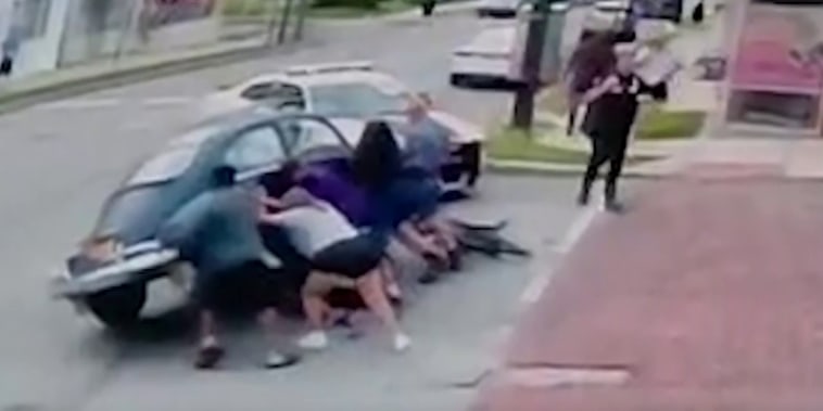 Voluntarios levantaron un auto para rescatar a una ciclista atrapada